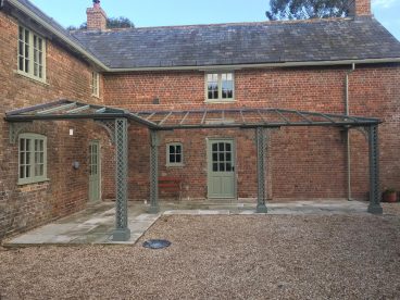 <p>Bespoke double hipped and valleyed verandah installed for Lord Julian and Lady Emma Fellowes at their estate in West Stafford. Built using our Lattice columns and arches, finished in a dark green to compliment the period features of this old building. </p>

