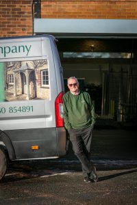 Richard Drake wearing a green sweatshirt, leaning against a van